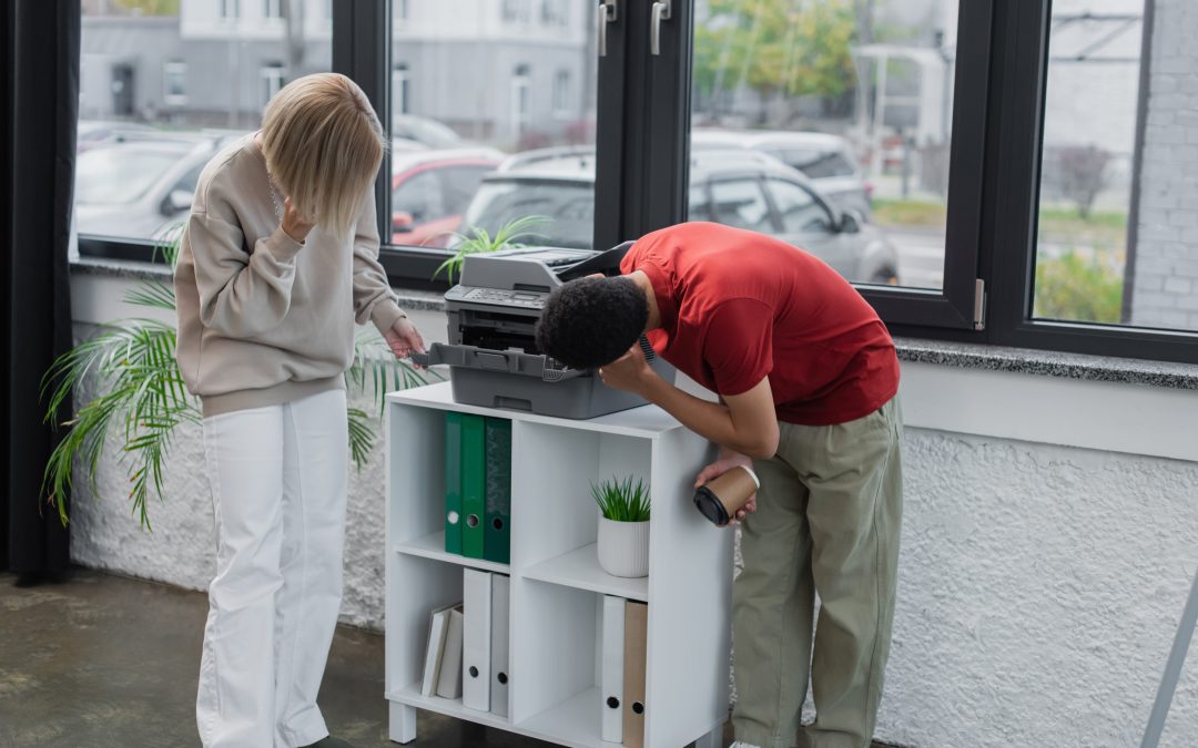 multiethnic colleagues looking at modern photocopier in office
